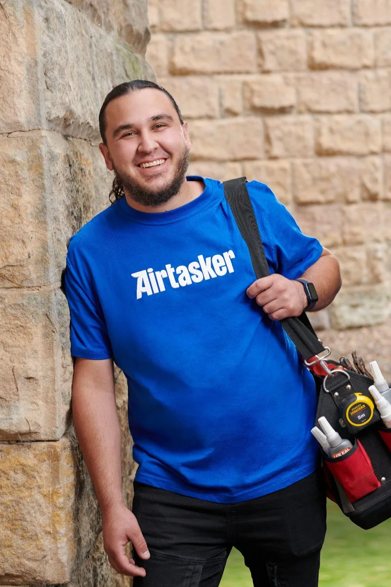 Airtasker representative wearing a blue Airtasker shirt and carrying a tool bag