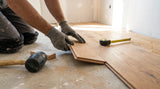 Installer fitting a warm oak engineered timber plank during installation