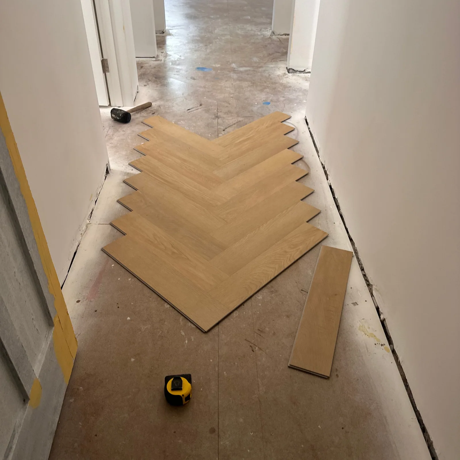 French Oak 9.5mm herringbone hybrid flooring during installation along a hallway