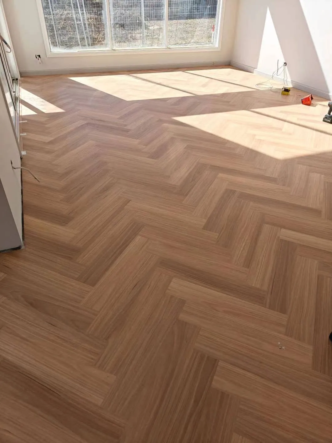 Natural Blackbutt 9.5mm herringbone hybrid flooring in a sunlit living room
