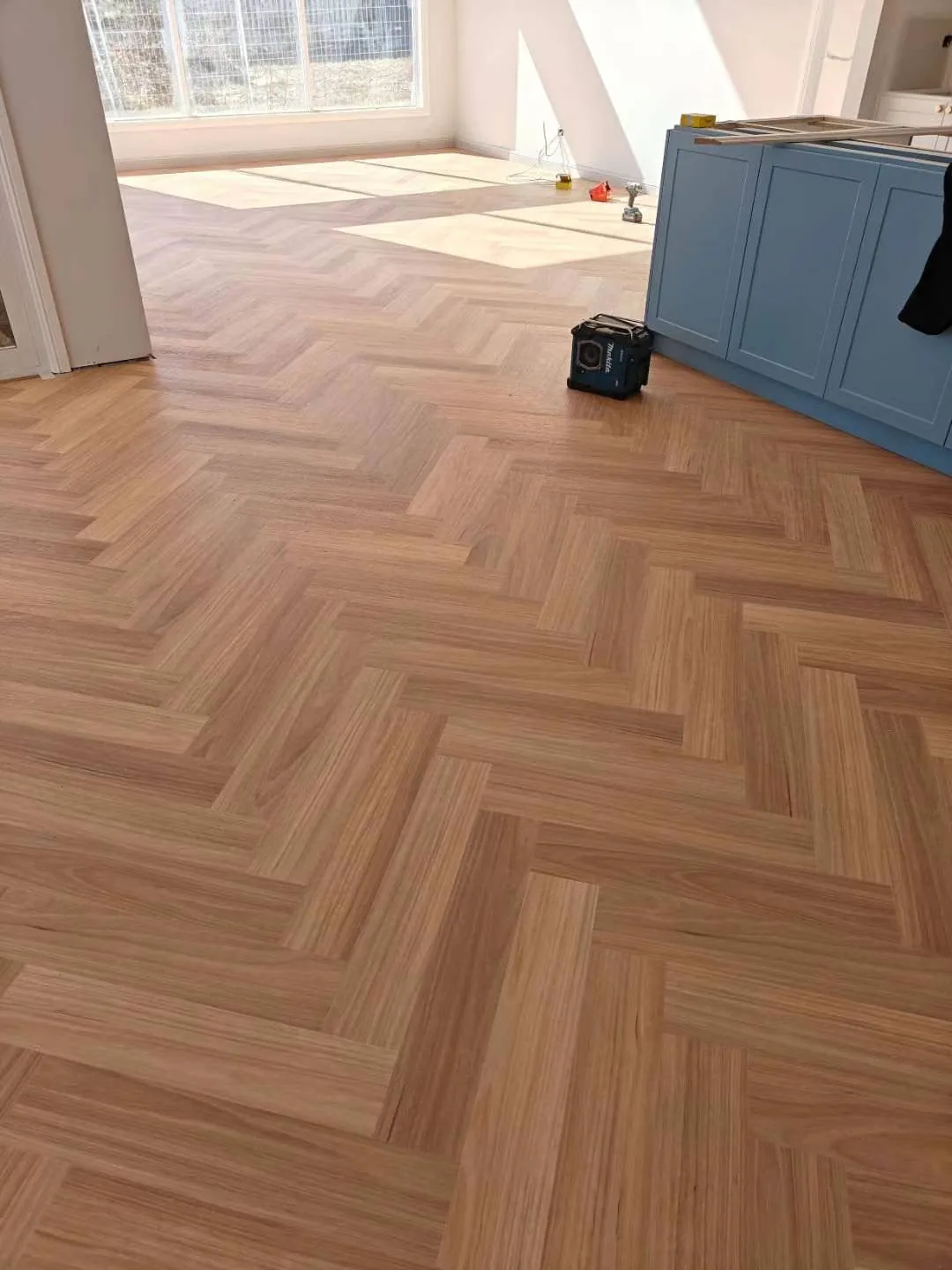 Natural Blackbutt 9.5mm herringbone hybrid flooring across a sunlit room