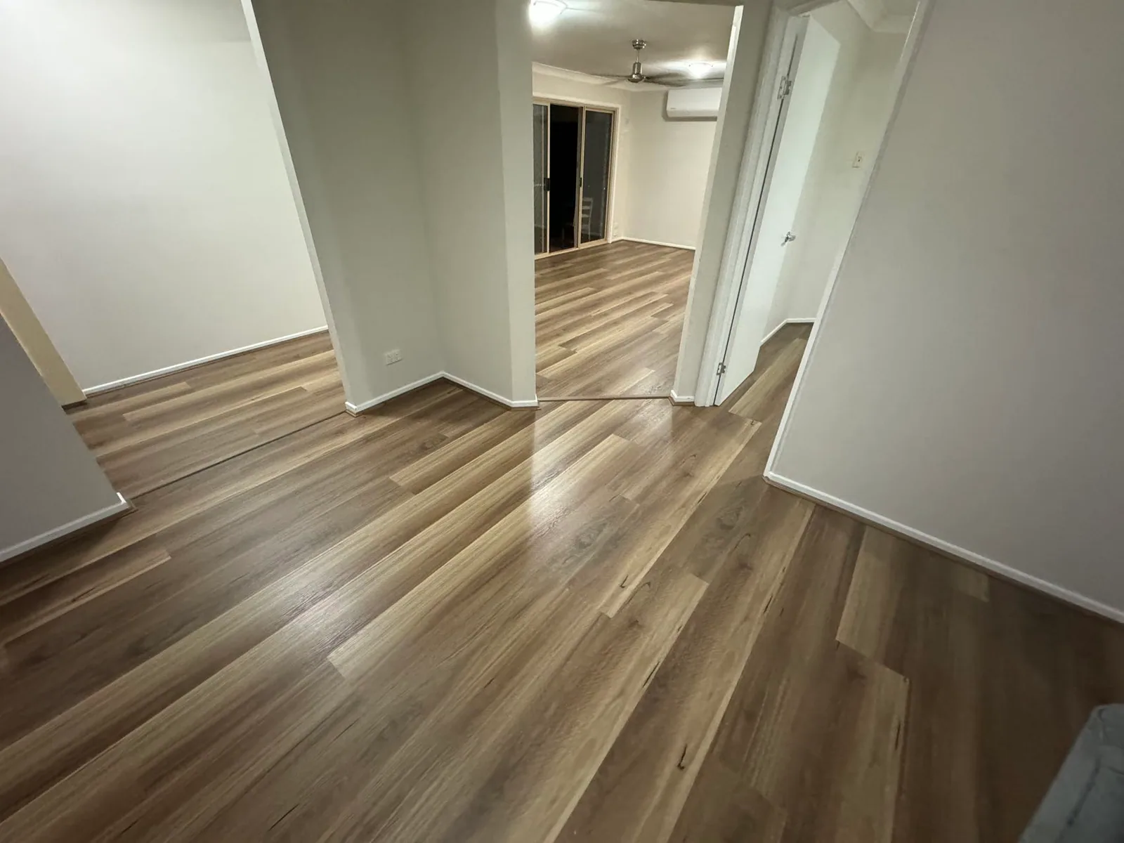 Natural Spotted Gum 9.5mm hybrid flooring across a room and hallway