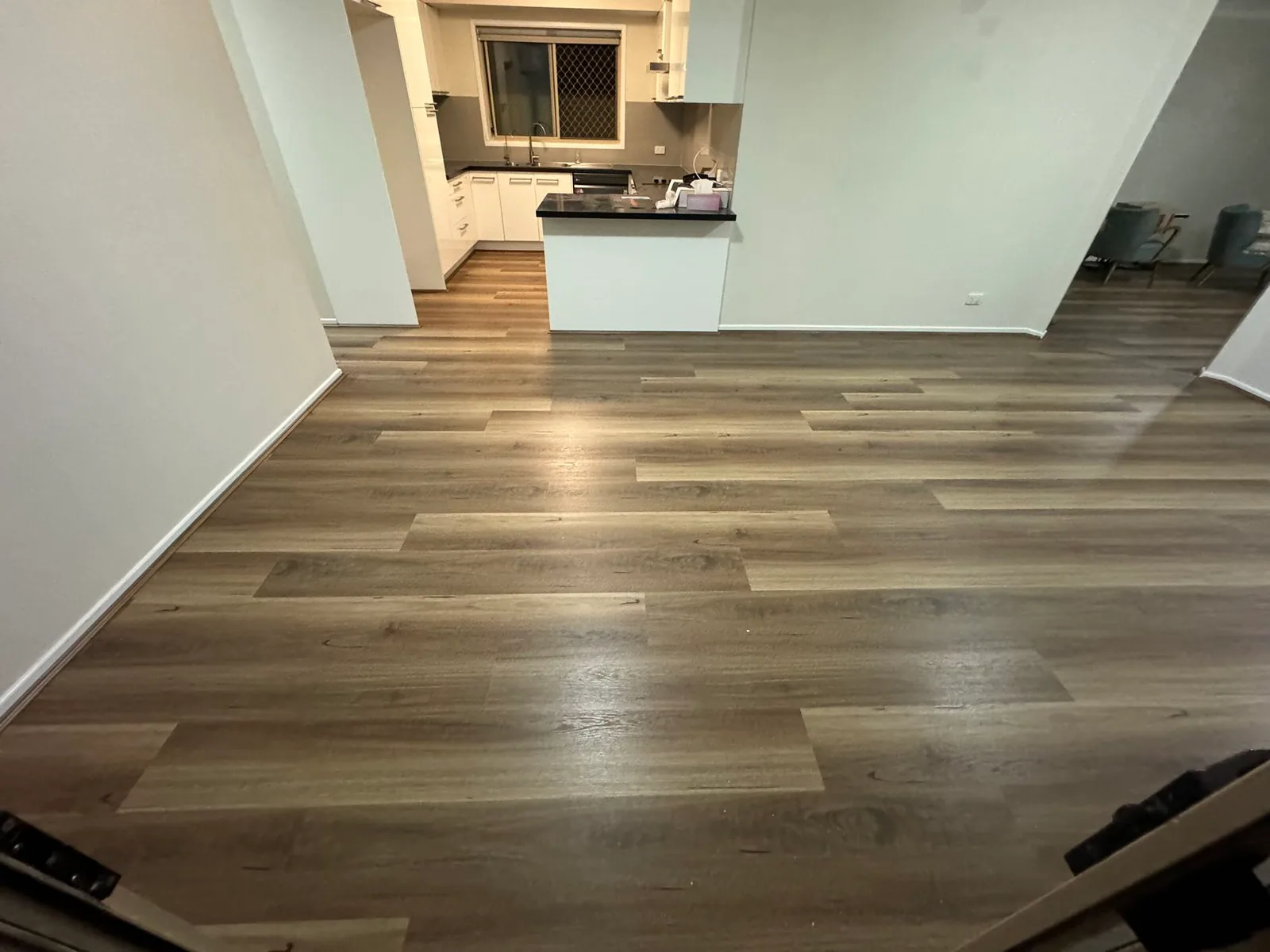 Natural Spotted Gum 9.5mm hybrid flooring across an open kitchen and dining space