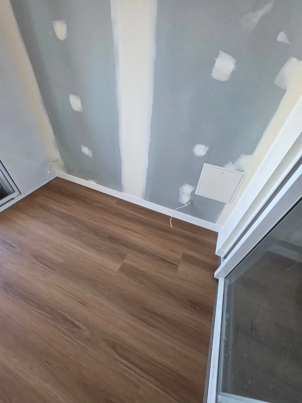 New England Blackbutt 9.5mm hybrid flooring at a doorway and unfinished wall during installation