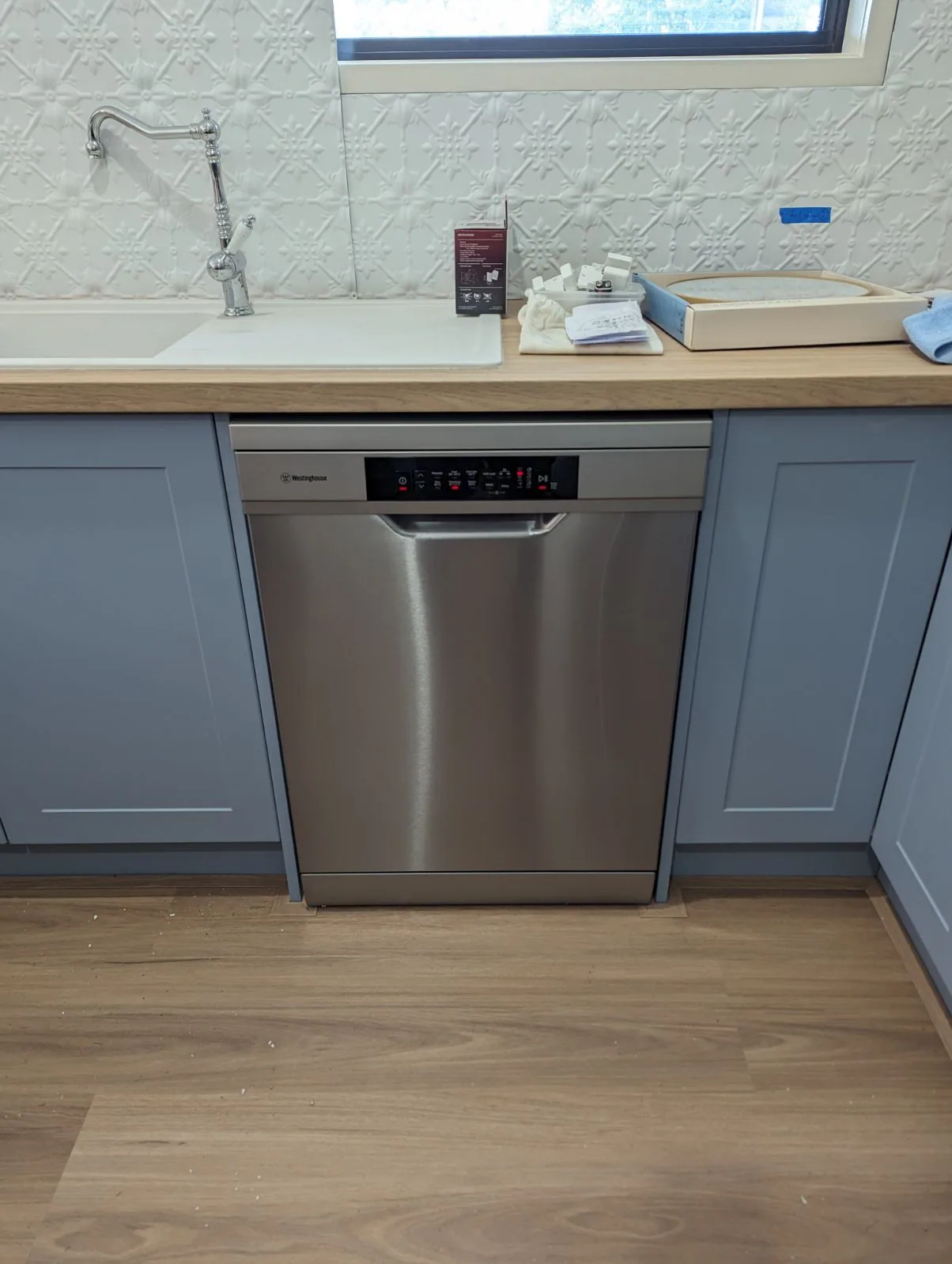 New England Blackbutt 9.5mm hybrid flooring beside grey kitchen cabinetry and a dishwasher