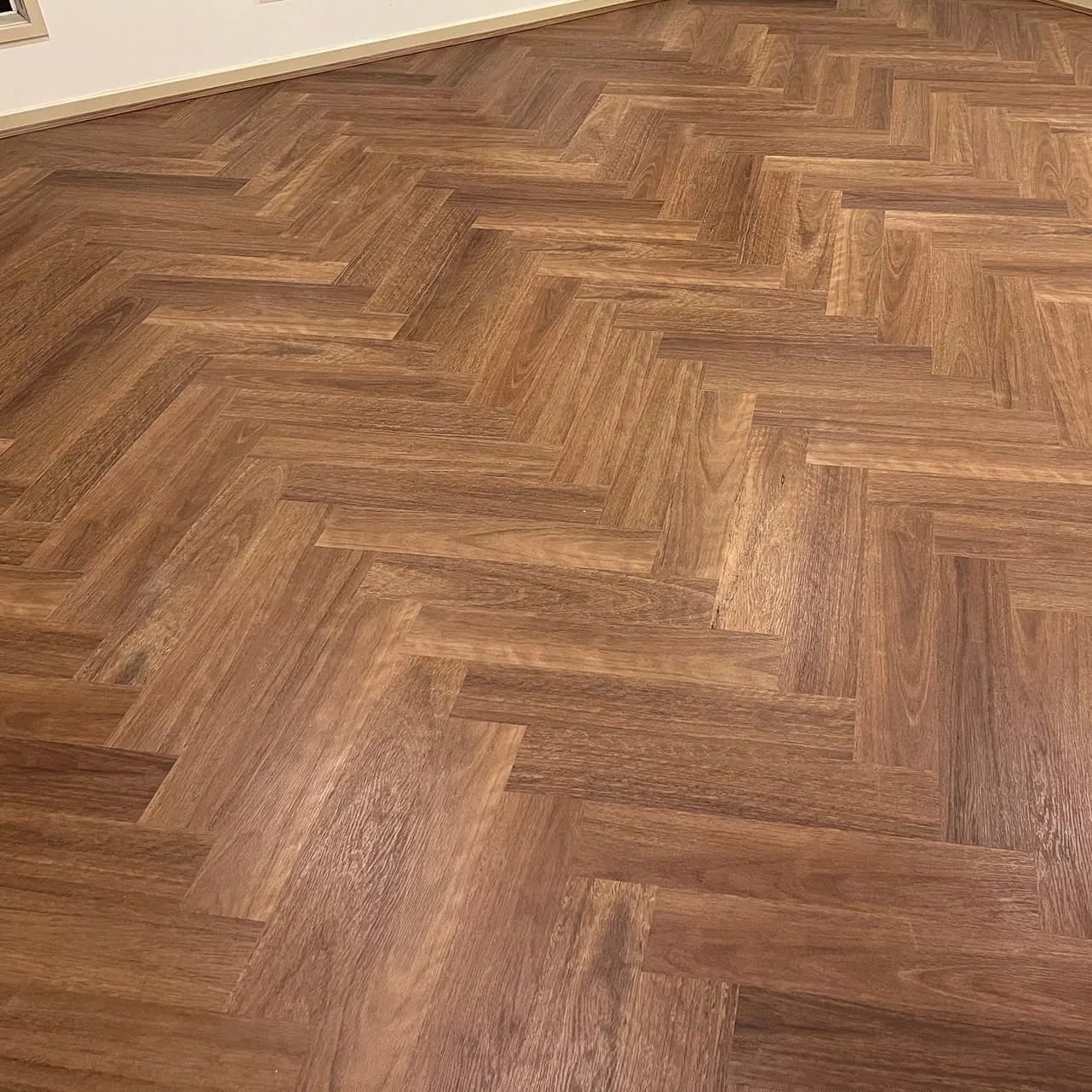 Pacific Spotted Gum 9.5mm herringbone hybrid flooring showing the pattern in an open room