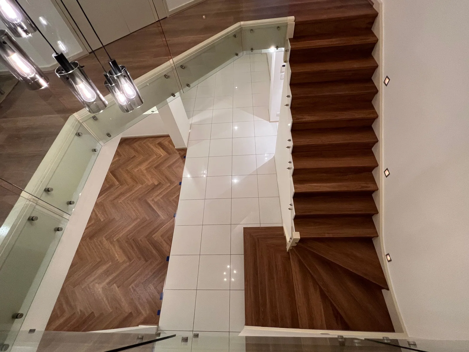 Pacific Spotted Gum 9.5mm herringbone hybrid flooring beside a staircase viewed from above