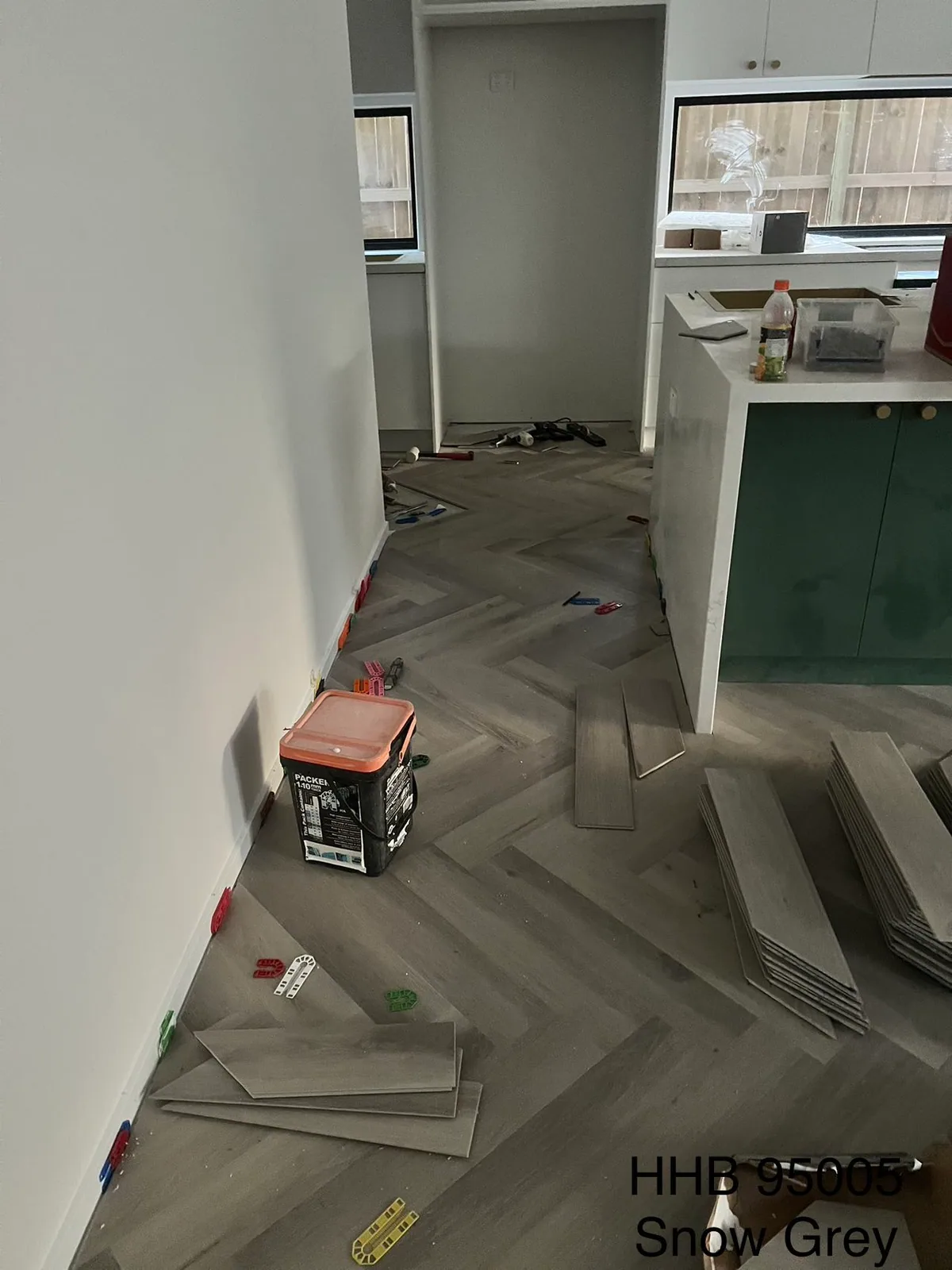 Snow Grey 9.5mm herringbone hybrid flooring along a kitchen entrance